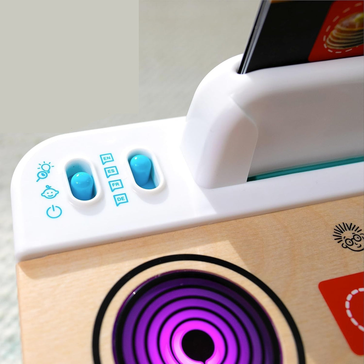 Zbliżenie niebieskich przełączników i okrągłego pola na blacie kuchni Baby Einstein Hape.