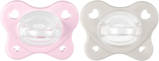 Dwa smoczki Chicco PhysioForma Dual Soft, różowy i szary, z przezroczystymi końcówkami.